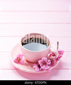 Cup of coffee and spring  flowers  ( peach) on pink wooden table. Stock Photo