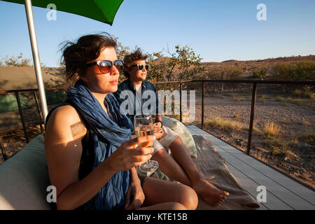 Young couple enjoying a drink at Huab Under Canvas, Damaraland, Namibia, Africa Stock Photo