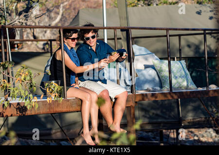 Couple on balcony of tent at Huab Under Canvas, Damaraland, Namibia, Africa Stock Photo