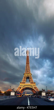 Eiffel Tower on a stormy evening reflecting  the last rays of setting Sun. Panoramic image, text space