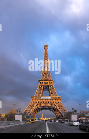 Eiffel Tower on a stormy evening with the last rays of setting Sun shining between the clouds. Panorama made from four horizontal images.