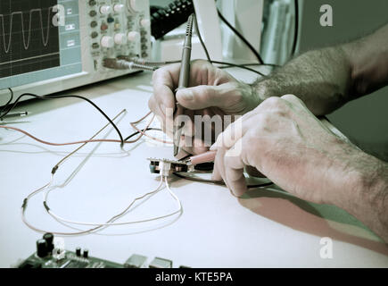 An engineer tests electronic components with oscilloscope in the service centre Stock Photo