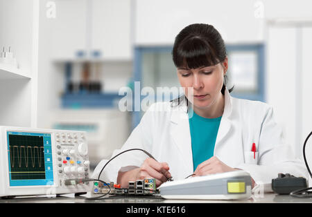 Tech repairs electronic device in modern laboratory Stock Photo