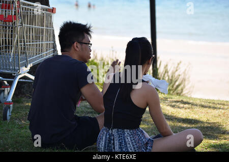 Young Asian couple sitting together talking Stock Photo