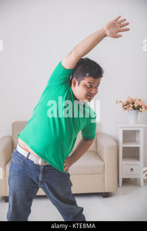 overweight man doing some exercise at home Stock Photo