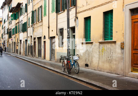 FIRENZE, ITALY - February 06, 2017 - Italian street with houses with green shutters , bicycles in Florence, Italy Stock Photo