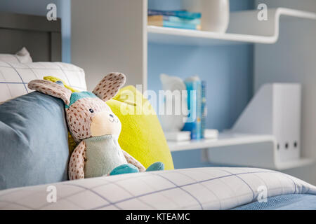 Rabbit soft toy on child’s bed interior UK