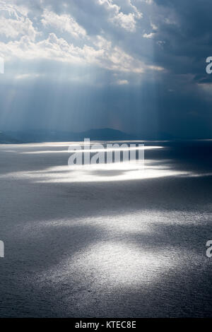 Sunbeams over sea at sunset. Stock Photo