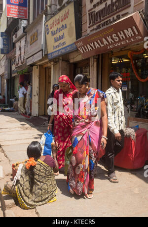 Female street vendor sitting on footpath and selling kiwifruit to customer in Bangalore, Bengaluru, Karnataka, India, Asia. Stock Photo