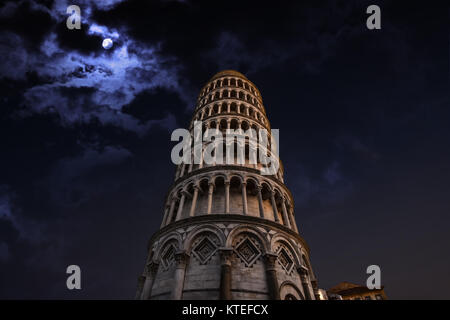 The leaning tower of Pisa Italy on the Square of Miracles illuminated late at night with a full moon behind Stock Photo