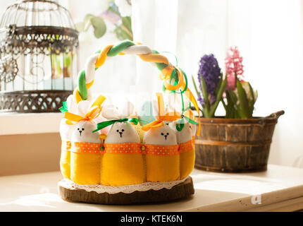 Easter decorations - textile basket with rabbits and eggs, morning light from window Stock Photo