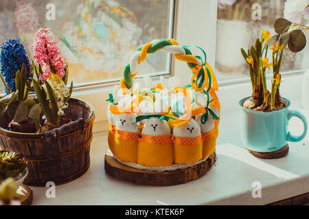 Easter decorations - textile basket with rabbits and eggs, morning light from window Stock Photo