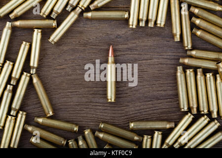 Rifle bullets on wood table with low key scene. Close-up photo. Stock Photo