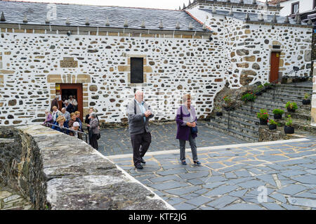 Faithful leaving the sanctuary after service at San Andres de Teixido, a very important pilgrimage place for Galician people. Cedeira, Coruna province Stock Photo