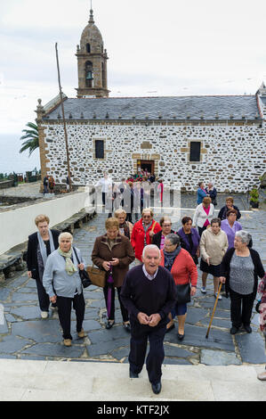 Faithful leaving the sanctuary after service at San Andres de Teixido, a very important pilgrimage place for Galician people. Cedeira, Coruna province Stock Photo