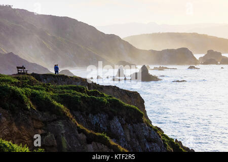 Travellers looking at the sunset at the Loiba cliffs (Acantilados de Loiba) Coruña province, Galicia, Spain, Europe Stock Photo