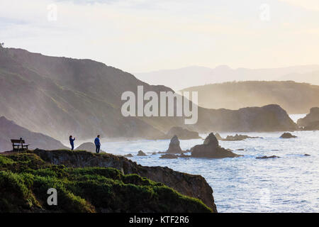 Travellers looking at the sunset at the Loiba cliffs (Acantilados de Loiba) Coruña province, Galicia, Spain, Europe Stock Photo