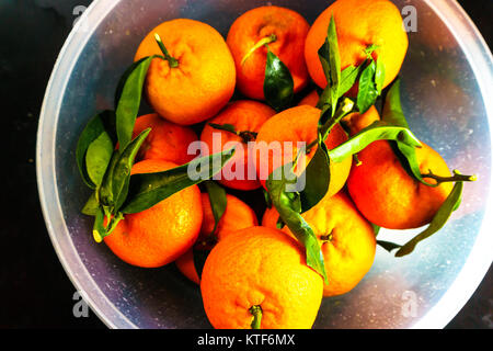 A basket of orange fruits, called sweet orange. The orange is the fruit of the citrus species Citrus × sinensis in the family Rutaceae. Stock Photo