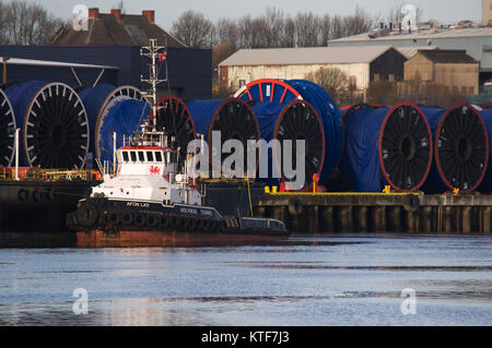 Cable bobbins and tug on River Tyne dockside near Wallsend, Tyne and Wear Stock Photo