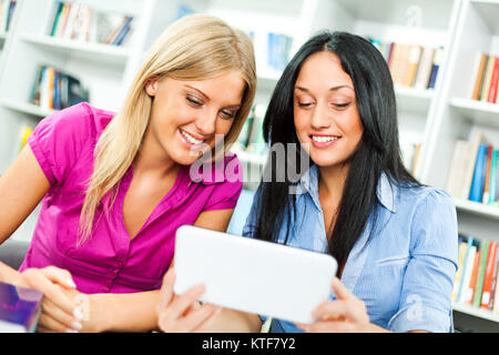 Students learning in library, using digital tablet Stock Photo