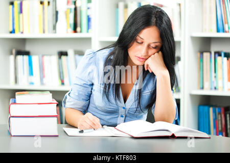 Tired student learning in library Stock Photo