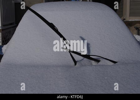 Car windscreen covered in fresh powdery snow, window wipers raised. Stock Photo