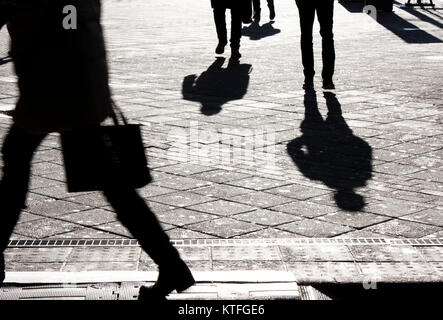People silhouettes and shadows on city streets in black and white Stock Photo