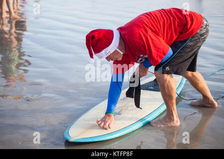 Cocoa Beach, Florida, USA. 24th Dec, 2017. Surfing Santas, an annual surf event taking place on Christmas Eve in Cocoa Beach, Florida where people dressed in Santa Claus costumes surf. Credit:  Lori Barbely/Alamy Live News Stock Photo