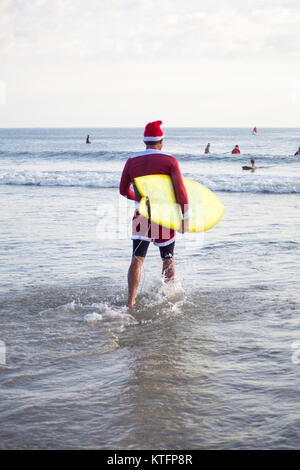 Cocoa Beach, Florida, USA. 24th Dec, 2017. Surfing Santas, an annual surf event taking place on Christmas Eve in Cocoa Beach, Florida where people dressed in Santa Claus costumes surf. Credit:  Lori Barbely/Alamy Live News Stock Photo