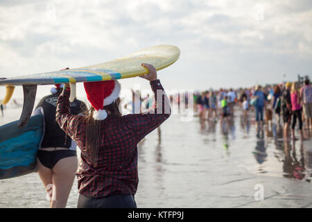 Cocoa Beach, Florida, USA. 24th Dec, 2017. Surfing Santas, an annual surf event taking place on Christmas Eve in Cocoa Beach, Florida where people dressed in Santa Claus costumes surf. Credit:  Lori Barbely/Alamy Live News Stock Photo