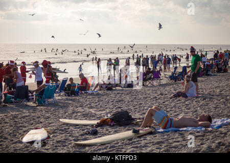 Cocoa Beach, Florida, USA. 24th Dec, 2017. Surfing Santas, an annual surf event taking place on Christmas Eve in Cocoa Beach, Florida where people dressed in Santa Claus costumes surf. Credit:  Lori Barbely/Alamy Live News Stock Photo