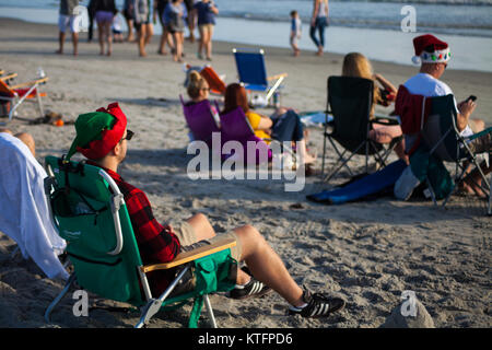 Cocoa Beach, Florida, USA. 24th Dec, 2017. Surfing Santas, an annual surf event taking place on Christmas Eve in Cocoa Beach, Florida where people dressed in Santa Claus costumes surf. Credit:  Lori Barbely/Alamy Live News Stock Photo