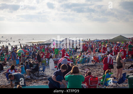 Cocoa Beach, Florida, USA. 24th Dec, 2017. Surfing Santas, an annual surf event taking place on Christmas Eve in Cocoa Beach, Florida where people dressed in Santa Claus costumes surf. Credit:  Lori Barbely/Alamy Live News Stock Photo