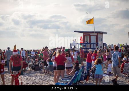 Cocoa Beach, Florida, USA. 24th Dec, 2017. Surfing Santas, an annual surf event taking place on Christmas Eve in Cocoa Beach, Florida where people dressed in Santa Claus costumes surf. Credit:  Lori Barbely/Alamy Live News Stock Photo