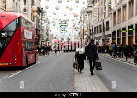 London, UK. 24th December 2017. UK weather. Thousands of Christmas shoppers visit London’s Oxford Street, one of Europe’s favourite and busiest shopping destinations, on a mild and overcast day to purchase last minute presents. Christmas Eve falls on a Sunday this year so the shops can only stay open for six hours, causing a mad rush before the shops re-open for Boxing Day sales. Stock Photo