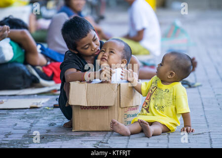 Cebu City, Philippines. 25th Dec, 2017. Homeless children playing with a box on the sidewalk  during Christmas Day morning 2017,Cebu City,Philippines Credit: imagegallery2/Alamy Live News Stock Photo