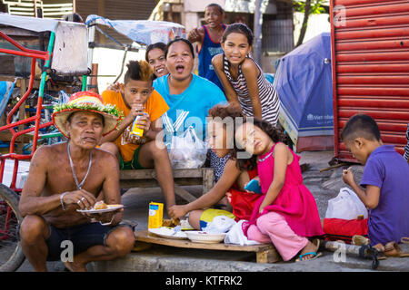 Cebu City, Philippines. 25th Dec, 2017. Homeless people sitting on the sidewalk & eating during Christmas Day morning 2017,Cebu City,Philippines Credit: imagegallery2/Alamy Live News Stock Photo