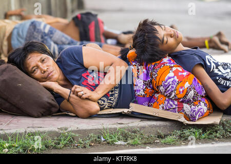 Cebu City, Philippines. 25th Dec, 2017. Homeless people along the sidewalk of a main street on Christmas day morning 2017,Cebu City,Philippines Credit: imagegallery2/Alamy Live News Stock Photo