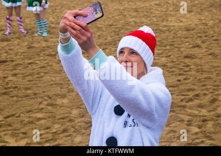 Boscombe, Bournemouth, Dorset, UK. Christmas Day 25th December 2017. Brave volunteers plunge into the cold choppy sea for a swim, for the 10th annual charity White Christmas Dip, dressed in fancy dress costumes and raising money for Macmillan Caring Locally at Christchurch, a Specialist Palliative Care Unit for patients in the local community. Hundreds take part in the event which has become a popular tradition for many before their Christmas lunch. Credit: Carolyn Jenkins/Alamy Live News Stock Photo