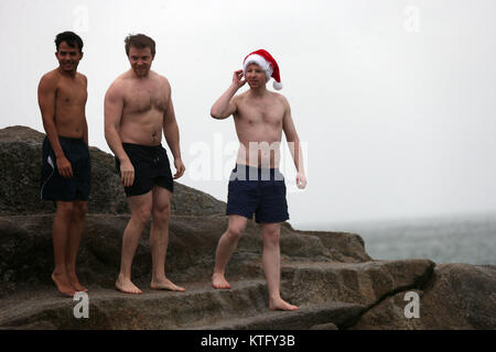 Sandycove, Ireland. 25th December 2017. People take part in the annual tradition of jumping into the forty foot, an open-sea bathing area, in Sandycove, Co Dublin. Credit : Laura Hutton/Alamy Live News. Stock Photo