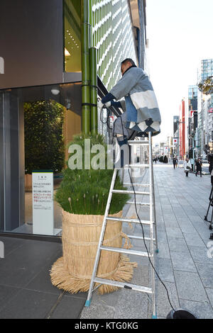 Tokyo, Japan. 26th Dec, 2017. In accordance with Japanese tradition, workers prepare New Year decorations at Ginza Six, a newly completed commercial complex in the heart of Tokyos Ginza shopping area on Tuesday, December 26, 2017. The pair of ornaments usually made of pine and bamboo is believed to honor and receive the deity, who will bring a bountiful harvest for farmers and bestow the ancestors blessing on everyone. The gates welcoming the deity is placed in front of homes across the country after Christmas until January 7. Credit: Natsuki Sakai/AFLO/Alamy Live News Stock Photo