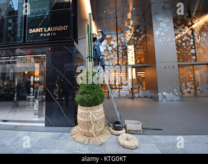 Tokyo, Japan. 26th Dec, 2017. In accordance with Japanese tradition, workers prepare New Year decorations at Ginza Six, a newly completed commercial complex in the heart of Tokyos Ginza shopping area on Tuesday, December 26, 2017. The pair of ornaments usually made of pine and bamboo is believed to honor and receive the deity, who will bring a bountiful harvest for farmers and bestow the ancestors blessing on everyone. The gates welcoming the deity is placed in front of homes across the country after Christmas until January 7. Credit: Natsuki Sakai/AFLO/Alamy Live News Stock Photo