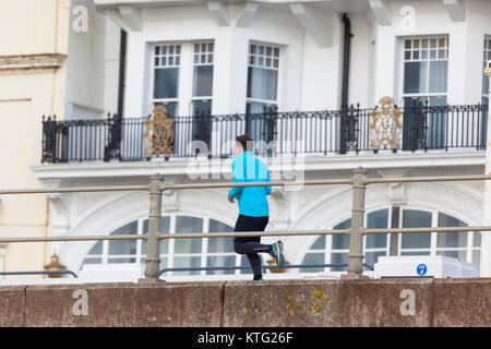 Hastings, East Sussex, UK. 26th December 2017.  Lots of people out and about enjoying the mild boxing day weather this morning. A jogger runs past on Hastings promenade. Photo Credit: Paul Lawrenson/ Alamy Live News Stock Photo