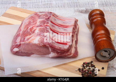 Raw pork chops and spice grinder on cutting board. Ready for cooking. Stock Photo