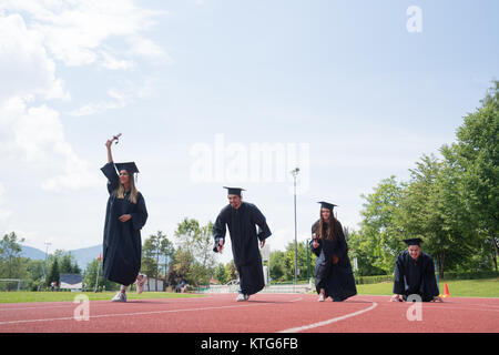 education, graduation and people concept - group of happy international students in mortar boards and bachelor gowns with diplomas Stock Photo