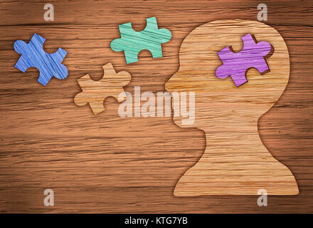 Puzzle head brain concept. Human head profile made from brown paper with a jigsaw piece cut out. Stock Photo