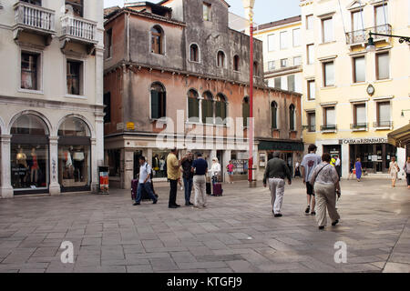 View of people walk early in the morning in Venice. It is the capital of northern Italy’s Veneto region, built on more than 100 small islands in a lag Stock Photo