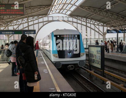 Wuhan Hubei China, 24 December 2017: Chinese people waiting metro on aerial line 1 in Wuhan China with train enering station Stock Photo