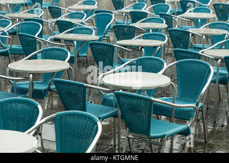 empty cafe chairs and table in San Marco square in the rain Stock Photo