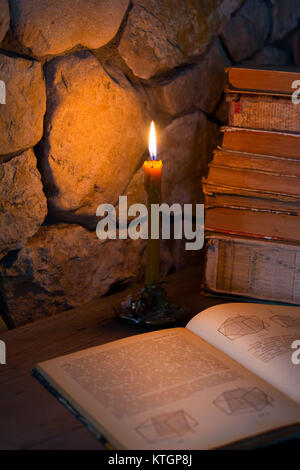 an open book and stop old books with candle, selective focus Stock Photo